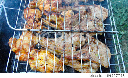 Beef cooked in an outdoor coal barbecue. Barbecue on a metal grill on hot coals. Beef cooked in an outdoor coal barbecue. Barbecue on a metal grill on hot coals. 69997743