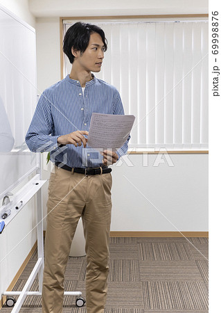 ホワイトボードの前に立つ若い男性(塾講師) ホワイトボードの前に立つ若い男性(塾講師) 69998876