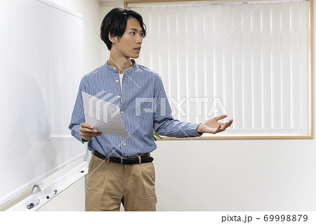 ホワイトボードの前に立つ若い男性(塾講師) ホワイトボードの前に立つ若い男性(塾講師) 69998879