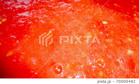 Red liquid organic tomato sauce in a white pot  70000482