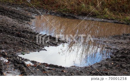 Puddle on a muddy road in autumn Puddle on a muddy road in autumn 70001258