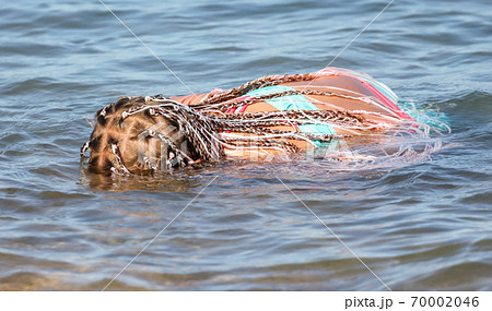 The girl swims in the water of the sea. 70002046