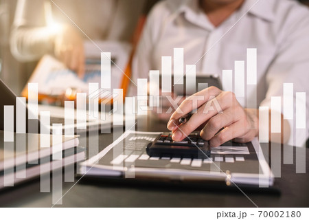 Businessman working on desk office with using a calculator to calculate the numbers, finance concept in office. Businessman working on desk office with using a calculator to calculate the numbers, finance concept in office. 70002180