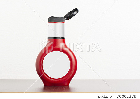 Tomato sauce bottle with cap on black table Tomato sauce bottle with cap on black table 70002379