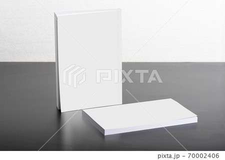 Books with blank cover on dark glossy table 70002406