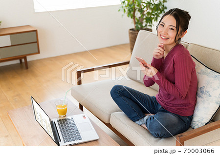 テレワーク中に一息入れてスマホを操作する女性 テレワーク中に一息入れてスマホを操作する女性 70003066