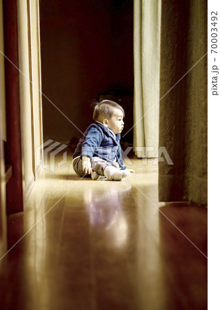 かわいい赤ちゃんが廊下から窓の外を見ている姿とコピースペース 70003492