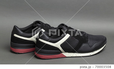 Pair of stylish black sneakers on a gray background. Insulated footwear. Pair of stylish black sneakers on a gray background. Insulated footwear. 70003508