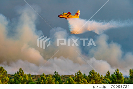 Profile view of hydroplane dumping water over huge fire Profile view of hydroplane dumping water over huge fire 70003724