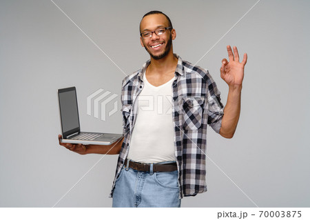 A young african american man working with a laptop pc 70003875