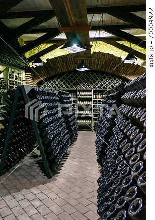Wine cellar with wine bottles. Old wine bottles covered with dust and cobwebs are in the wine cellar of winery. Alcohol drink vintage storage 70004922