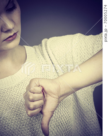 Sad woman showing thumb down gesture Sad woman showing thumb down gesture 70005274