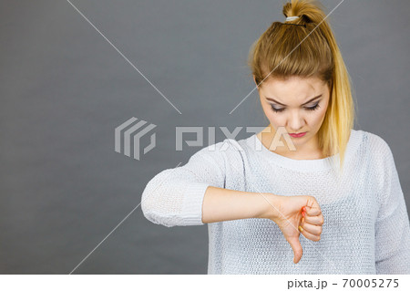 Sad woman showing thumb down gesture Sad woman showing thumb down gesture 70005275