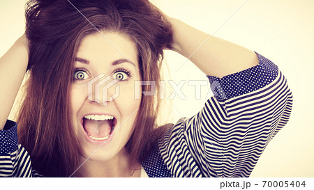 Woman having shocked amazed face expression 70005404