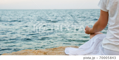 Woman meditating at the sea Woman meditating at the sea 70005843