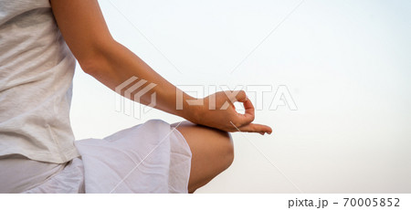Woman meditating at the sea Woman meditating at the sea 70005852