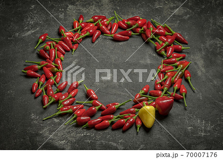 Red hot chilli peppers oval frame on a black cement table with copy space. Red hot chilli peppers oval frame on a black cement table with copy space. 70007176
