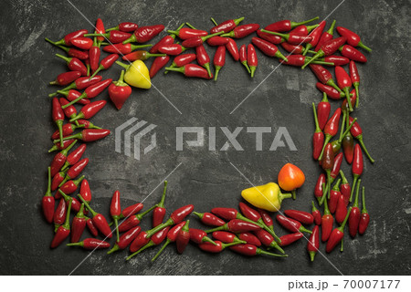 Red hot chilli peppers rectangle frame on a black table, top view with copy space for your culinary text. Red hot chilli peppers rectangle frame on a black table, top view with copy space for your culinary text. 70007177