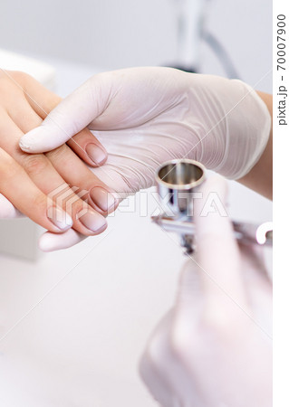 Woman receiving manicure by airbrush Woman receiving manicure by airbrush 70007900