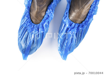 Blue protective shoe covers on female shoes isolated on white background. Blue protective shoe covers on female shoes isolated on white background. 70010044