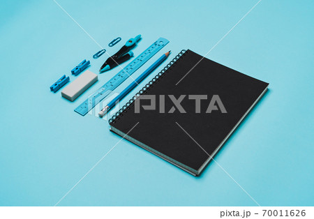 book, pencil, ruler on a blue background. 70011626