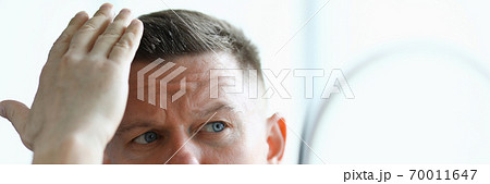 Man makes his hair with gel closeup 70011647