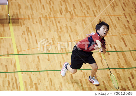 バドミントンの試合をする小学生男子 70012039