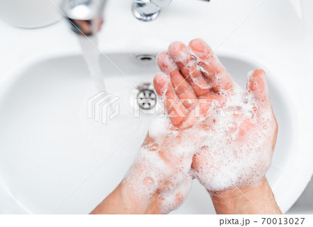 Personal hygiene, cleaning hands with soap often on faucet to protect from virus. 70013027