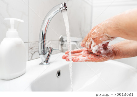 Personal hygiene, cleaning hands with soap often on faucet to protect from virus. 70013031