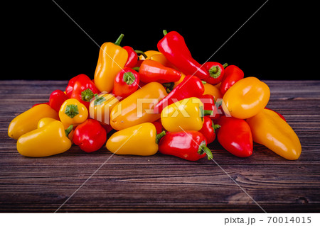Fresh colored bell peppers on a rustic wooden background. Fresh colored bell peppers on a rustic wooden background. 70014015