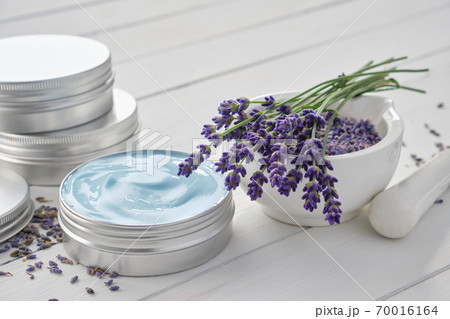 Natural organic lavender cream, mortar and bunch of dry lavender flowers on white wooden table. 70016164