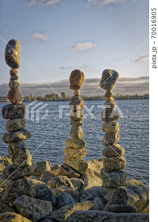 The art of Rock balancing with water, clouds and sky in the background 70016905