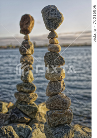 The art of Rock balancing with water, clouds and sky in the background 70016906