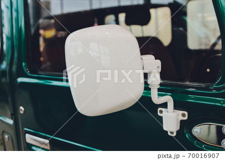 green dirty car in dust side view on the door and mirror on a sunny day, closeup background on auto theme. 70016907