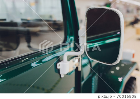green dirty car in dust side view on the door and mirror on a sunny day, closeup background on auto theme. 70016908