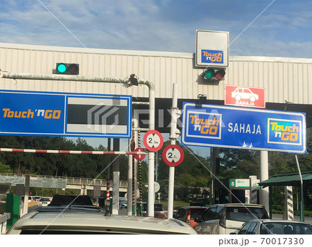 SEREMBAN, MALAYSIA -AUGUST, 2020: Vehicles entering highway toll canopy in Malaysia. Vehicles that use the expressway through a toll plaza and make payments each time they enter and exit. SEREMBAN, MALAYSIA -AUGUST, 2020: Vehicles entering highway toll canopy in Malaysia. Vehicles that use the expressway through a toll plaza and make payments each time they enter and exit. 70017330