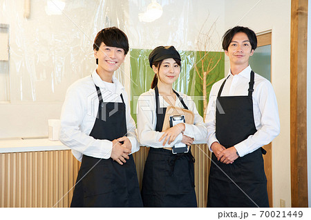 ビニールパーテーションのあるカフェのレジの前に立つ店員 70021449