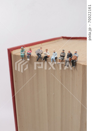 mini people sitting on book using as background education or business concept 70022161