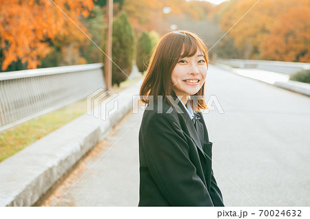 夕陽に照らされる女子高生 70024632