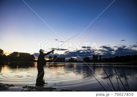 USA, Utah, Salem, Silhouette of man fly fishing in lake at dusk USA, Utah, Salem, Silhouette of man fly fishing in lake at dusk 70027850