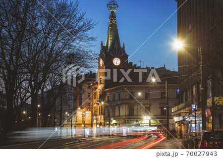 Poland, Lesser Poland, Krakow, Illuminated city street with clock tower at night Poland, Lesser Poland, Krakow, Illuminated city street with clock tower at night 70027943