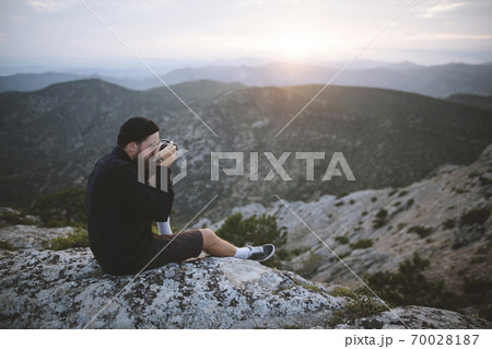 Italy, Liguria, La Spezia, Man photographing mountain range from mountain top 70028187