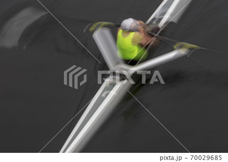 A single scull boat and rower on the water, view from above. Motion blur A single scull boat and rower on the water, view from above. Motion blur 70029685