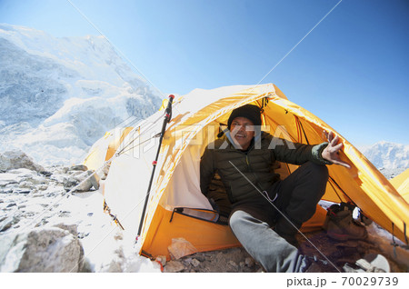 Man sitting in base camp tent in the Himalayas Man sitting in base camp tent in the Himalayas 70029739