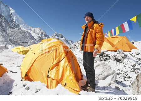 Man standing at base camp tent 70029818