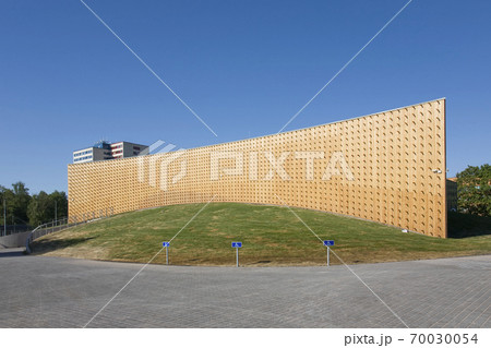 Modern university buildings, wooden beams projecting from a curved wood cladding wall, on a curved ground surface 70030054
