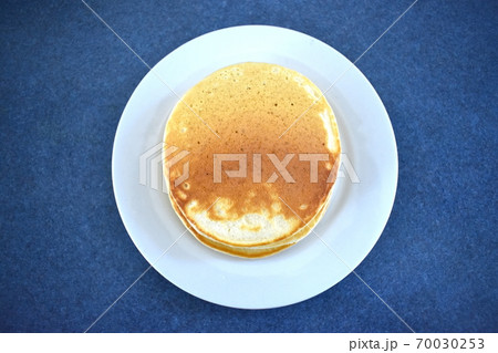 A stack of three pancakes on a plate 70030253