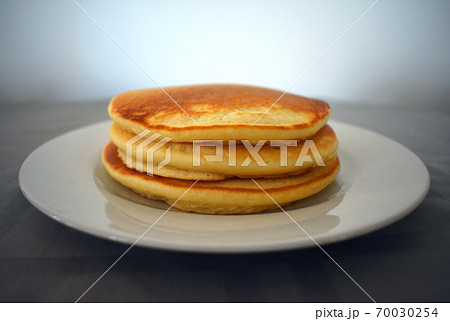 A stack of three pancakes on a plate 70030254
