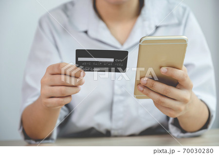 Businessman hand hold credit card to online shopping on smartphone from home, payment e-commerce, internet banking, spending money for next holidays Businessman hand hold credit card to online shopping on smartphone from home, payment e-commerce, internet banking, spending money for next holidays 70030280