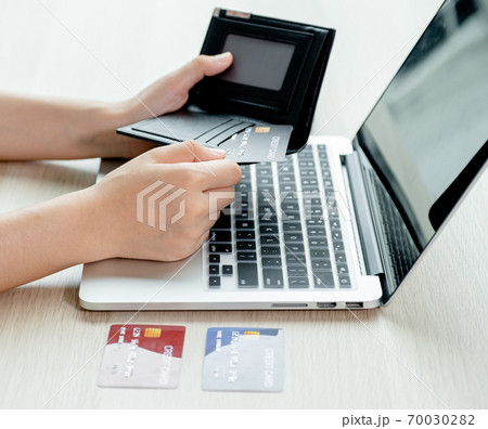 Businesswomen hand take credit cards out of pocket to online shopping on a laptop computer from home for next holidays, payment e-commerce, internet banking, spending money Businesswomen hand take credit cards out of pocket to online shopping on a laptop computer from home for next holidays, payment e-commerce, internet banking, spending money 70030282